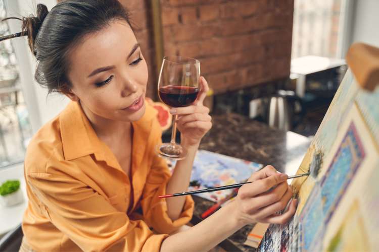 paint and sip in Sacramento woman painting while drinking wine